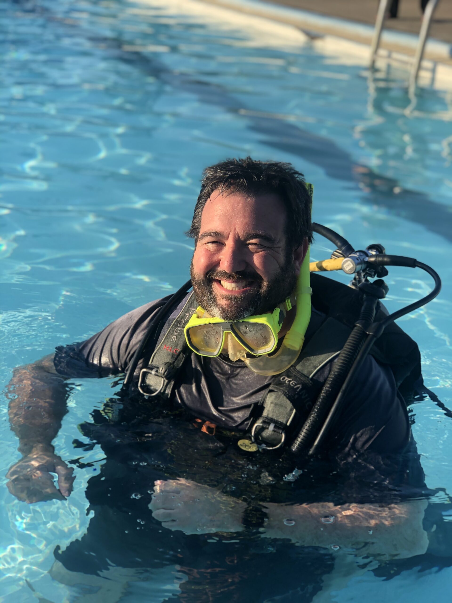 Brian in scuba giving gear smiling head above water